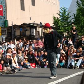 大勢の観客の前でパフォーマンスをする大道芸人「ミスターバード」