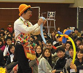 体育館でのイベントで次々にバルーンを作って観客を楽しませる大道芸人