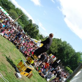 ローラーを積み重ねた上に乗るバランス芸を披露する大道芸人