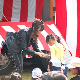 観客の女の子にトランプを選んでもらう女性マジシャン