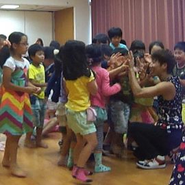 ショー後に子ども達とハイタッチをする大道芸人