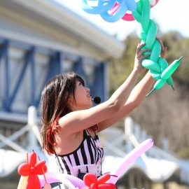 色とりどりの風船で可愛いバルーンアートを作る女性パフォーマー