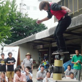 ローリングバランスを成功させて観客から拍手をもらう大道芸人