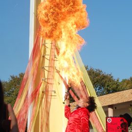 口から火を噴くパフォーマンスをする大道芸人