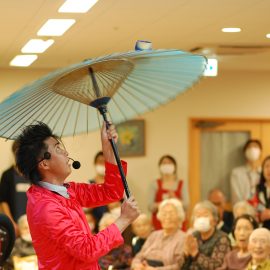 和風の芸もこなす赤い衣装が特徴の大道芸人