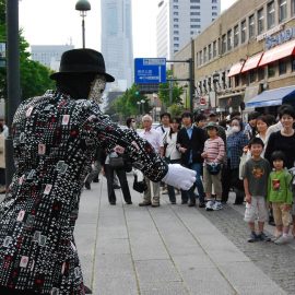 たくさんの人に囲まれてアニメーションダンスをするパントマイムパフォーマー