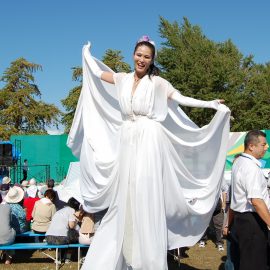 白い衣装で会場内を練り歩くスティルトパフォーマー