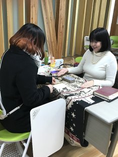 文化祭の無料タロット占いコーナーで女性を占っている占い師