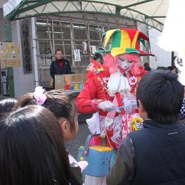 屋外でバルーングリーティングをしてお子様に大人気の女性クラウン